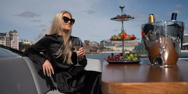 Gjest med glass på akterdekket på Oslofjorden